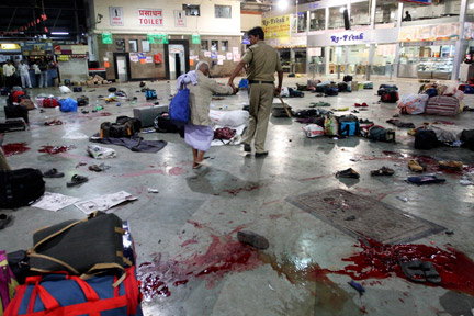 Un policier accompagne une victime, après la fusillade, dans la gare de Bombay, en Inde, le 26 novembre 2008. (Photo : Reuters)